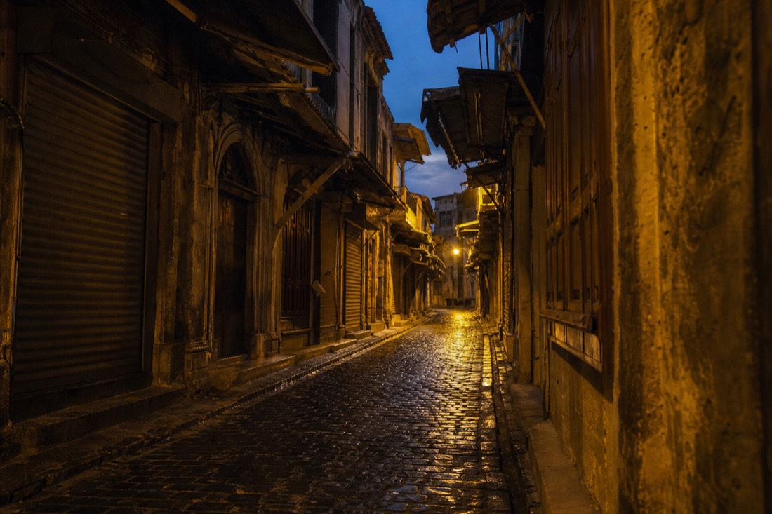 Narrow cobbled old-Istanbul lane with Ottoman-era shopfronts near the bazaar at evening