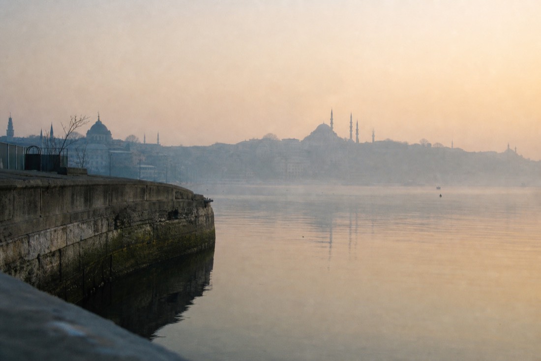 Golden Horn waterfront at hazy dawn with old stone quay walls near Topkapi Palace