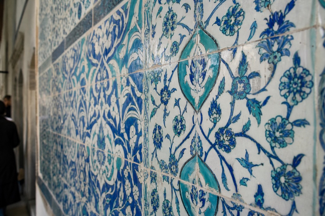 Blue and white Iznik tile panel detail on a Topkapi Palace wall in soft daylight